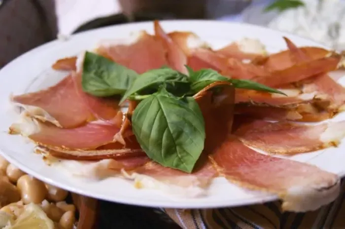 Framed Print : Dried dry cured ham with basil leaves on a white plate. Tradita traditional restaurant, Shkodra