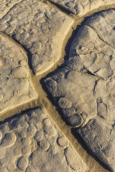 Dried mud cracks of ancient lakebed in The Mesquite sand dunes in Death Valley National Park
