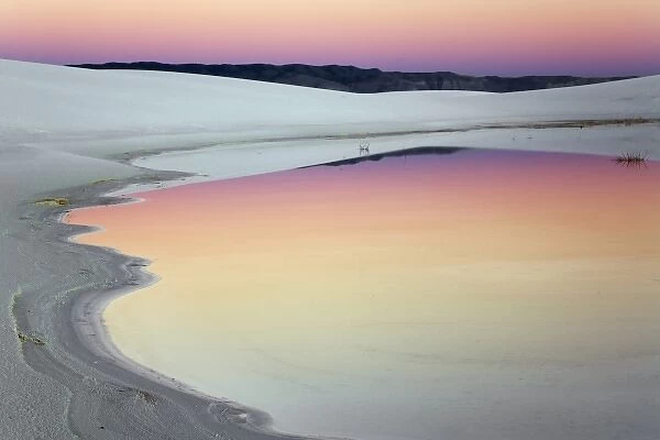 Dusk sky reflected in pool of water from recent rains, White Sands National Monument