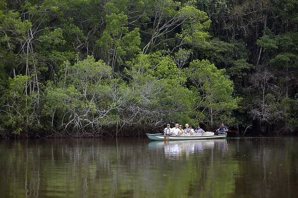 Ecuador, Orellana, Napo River. Tourists viewing wildlife in a canoe, La Selva Amazon