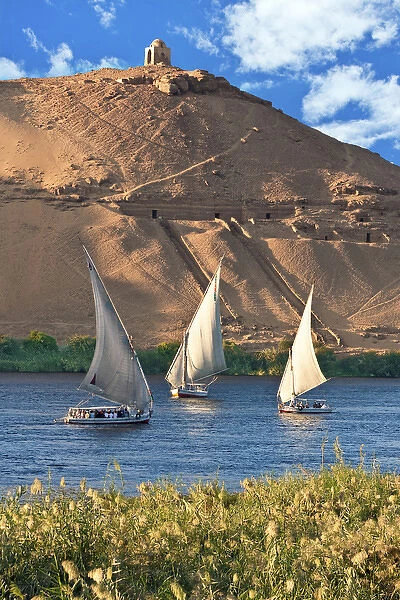 Egypt, Aswan, Nile River, Felucca sailboats, temple ruins and the large sand dunes