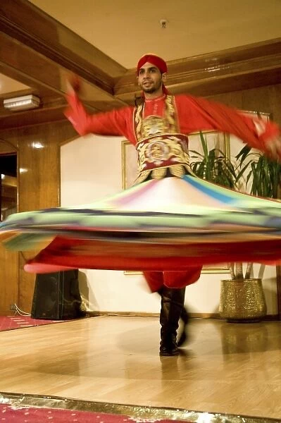 Egypt, Cairo. Whirling dervish dazzling GCT audience on Nubian Night aboard MS River