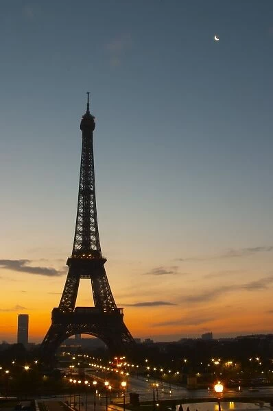 The Eiffel Tower in Paris in early morning, pale blue sky some white clouds and the