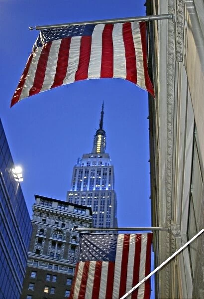 Empire State Building framed by American flag at dusk New York City
