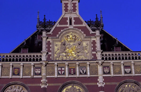 EU, Netherlands, Amsterdam. Central Station, red brick building with ornate gold