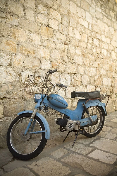 Europe, Croatia, Dalmatia, Hvar Island, Hvar town, blue scooter bike by old stone wall