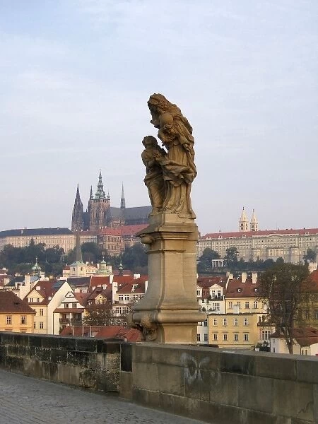 Europe, Czech Republic, Prague. A statue of St. Anne, with Prague Castle in the background