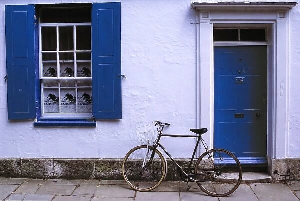 Europe, England, Oxfordshire. A bicycle leans against a white-washed home in Oxfordshire in England