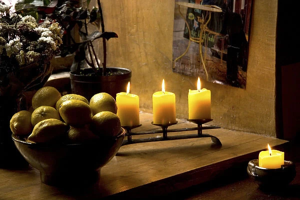 Europe, Estonia, Tallinn. Still life with lighted candles and bowl of lemons inside coffee shop