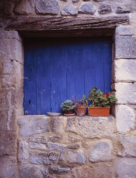 Europe, France, Cereste. A blue door adds color to this grey stone wall in Cereste