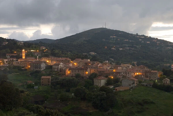 Europe, France, Corsica, Piana. Lights of Piana at dusk with storm clouds