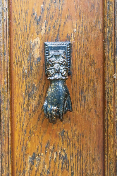 Europe, France, Dordogne, Hautefort. A metal door knocker in the shape of a hand in the
