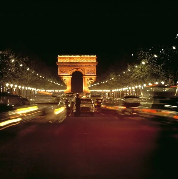 Europe, France, Paris. Evening traffic rushes along Champs d Elysses toward the
