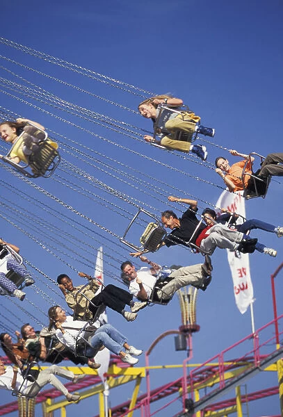 Europe, Germany, Munich. Visitors enjoying the ride high above the crowd during Octoberfest