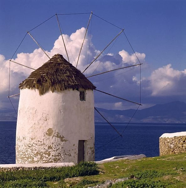 Europe, Greece, Mykonos. A striking white windmill looks over the azure sea in Mykonos, Greece