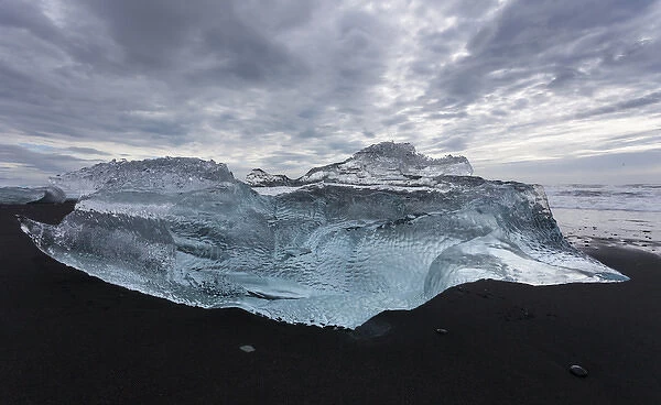 Europe, Iceland. Iceberg piece from Jokulsarlon Lagoon washed onto black sand beach by storm