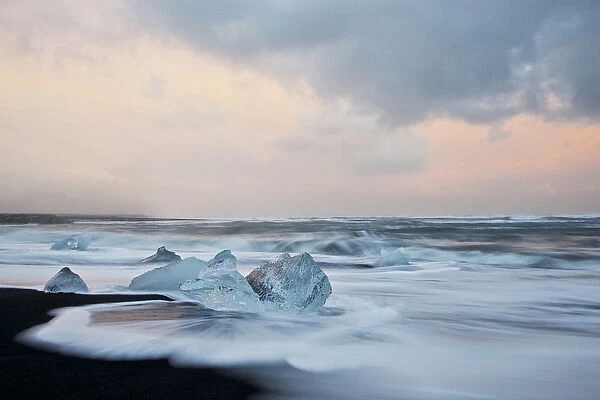 Europe, Iceland, Jokulsarlon Glacier Lagoon. Waves wash beached icebergs. Credit as