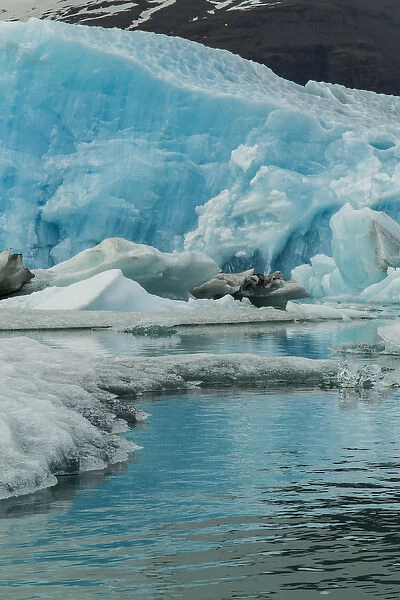 Europe, Iceland, Jokusarlon. Blue iceberg reflects in water