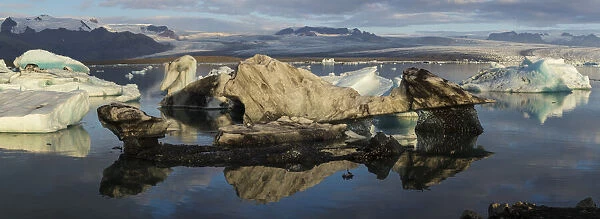 Europe, Iceland. Morning light shines on a panoramic view of icebergs floating in