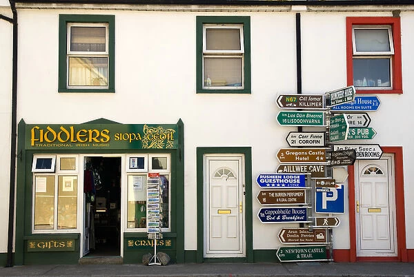 Europe, Ireland, Ballyvaughan. Store fronts and an informative sign post in the village center