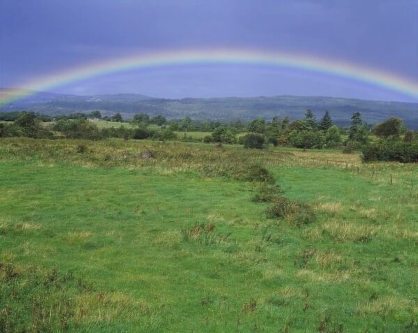 Europe, Ireland, Co. Donegal. The complete arc of a rainbow fills the sky over a