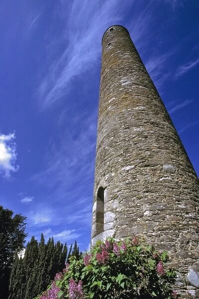 Europe, Ireland, Glendalough. A tall, round tower reaches to the blue, cloud-brushed
