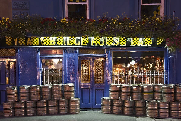 Europe, Ireland, Kilkenny. Nighttime exterior of pub with beer barrels in front. Credit as