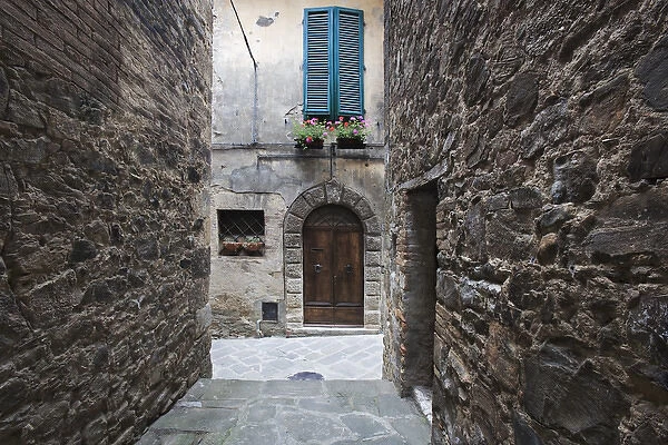 Europe, Italy, Petroio. Narrow walkway frame a doorway in a Tuscany village. Credit as