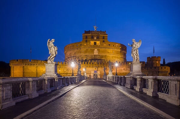 Europe, Italy, Rome. Bridge to Castel Sant Angelo lit at night
