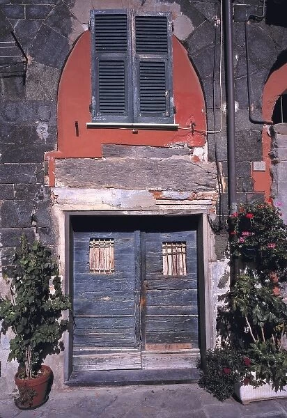 Europe, Italy, Vernazza. Blue wooden doors are accented by the red walls and ancient