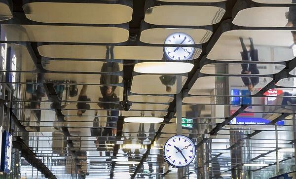 Europe, Netherlands, Amsterdam. Commuters reflected in ceiling of central train station