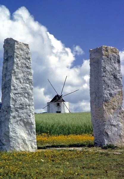 Europe, Portugal, Leiria. Stone pillars frame this windmill in the Leiria District, Portugal