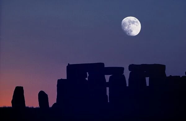 Europe, Stonehenge. The moon sets over prehistoric Stonehenge, a World Heritage Site