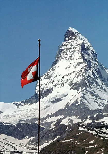 Europe, Switzerland, Matterhorn. The Swiss flag flies proudly at the base of the