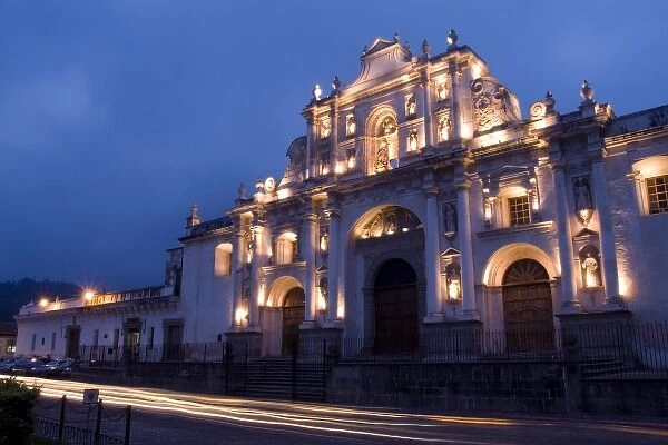 Evening at Cathedral de Santiago at twilight with streaks of traffic in town of Antigua