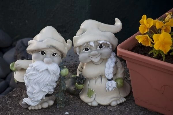 Fanciful troll figures by a flower box at the entrance to an Icelandic home