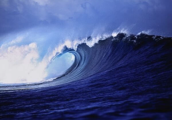 Fiji Islands, Tavarua, Cloudbreak. A stunning wave curl reveals impossible shades of blue
