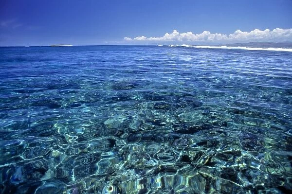 Fiji Islands, Tavarua. This coral reef on Tavarua is visible beneath the clear, aquamarine water