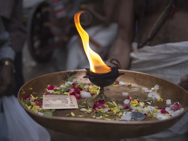 A fire burns in a golden bowl in Bangalore, Karnataka, India