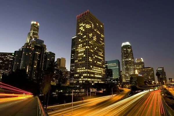 First light from sunrise illuminates downtown Los Angeles wih traffic streaking across