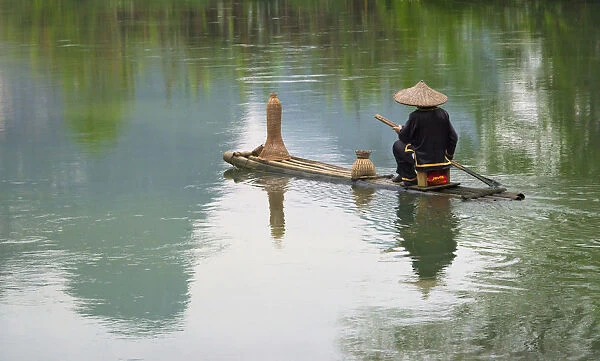 Fisherman on bamboo raft on Mingshi River with karst hills, Mingshi, Guangxi Province