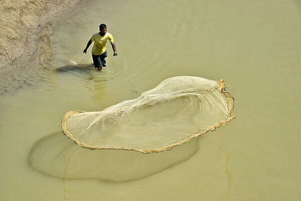 Fisherman casting fish net on the river, Chittagong