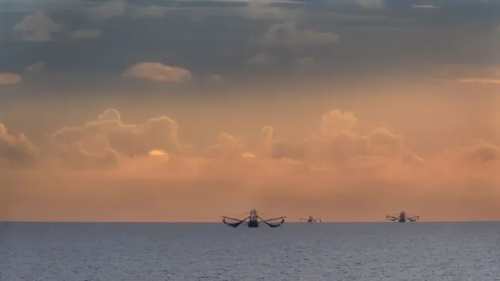 Framed Print : Fishing boats deep out to sea against the backdrop of dramatic sunset clouds and sky Framed Print : Fishing boats deep out to sea against the backdrop of dramatic sunset clouds and sky