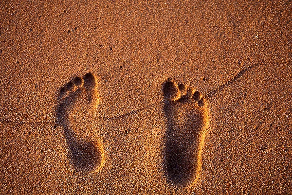 Footprints in the sand on a Kauai beach, in Hawaii