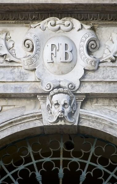 France, Corsica. Grotesque face and ornate decoration on pediment above door in Ajaccio