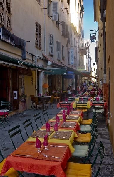 France, Corsica. Tables of cafe set up in narrow street in preparation for the evenings diners