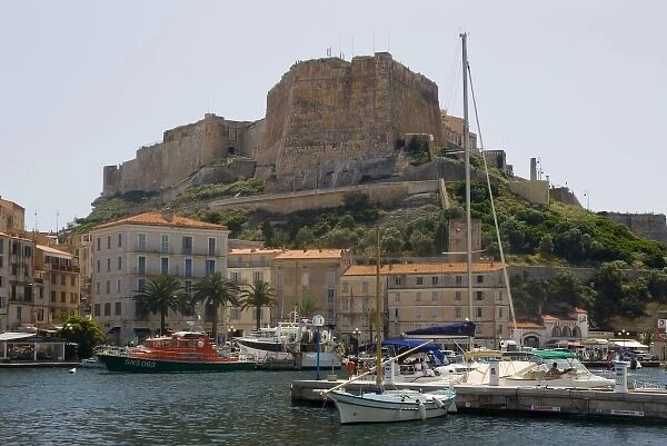 France, Corsica. Walled citadel enclosing the old city rises above the inner harbor at Bonifacio