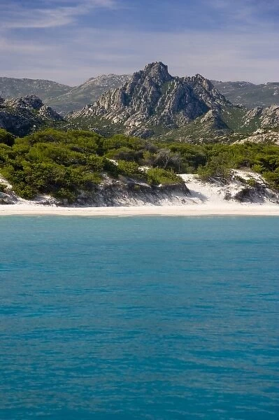 France, Corsica. White sand and clear water at Saleccio Beach below rugged terrain of DA