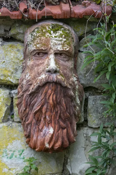 Framed Print : France, Giverny. Stone face hanging on a stone wall. Credit as Framed Print : France, Giverny. Stone face hanging on a stone wall. Credit as