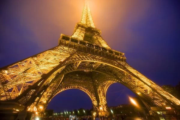 France, Paris. Looking up from base of Eiffel Tower lit at night. Credit as: Jim